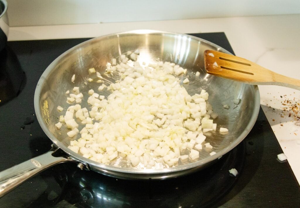 sauteing onions in a pan on the stove