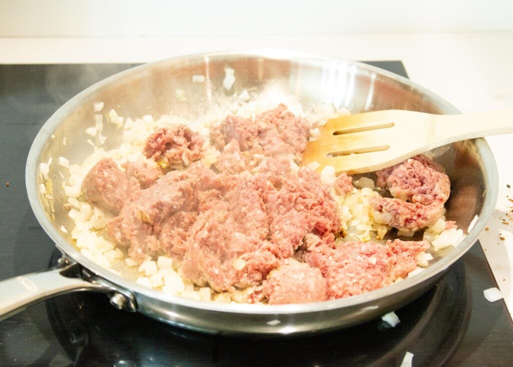ground beef and onions in a pan on the stove