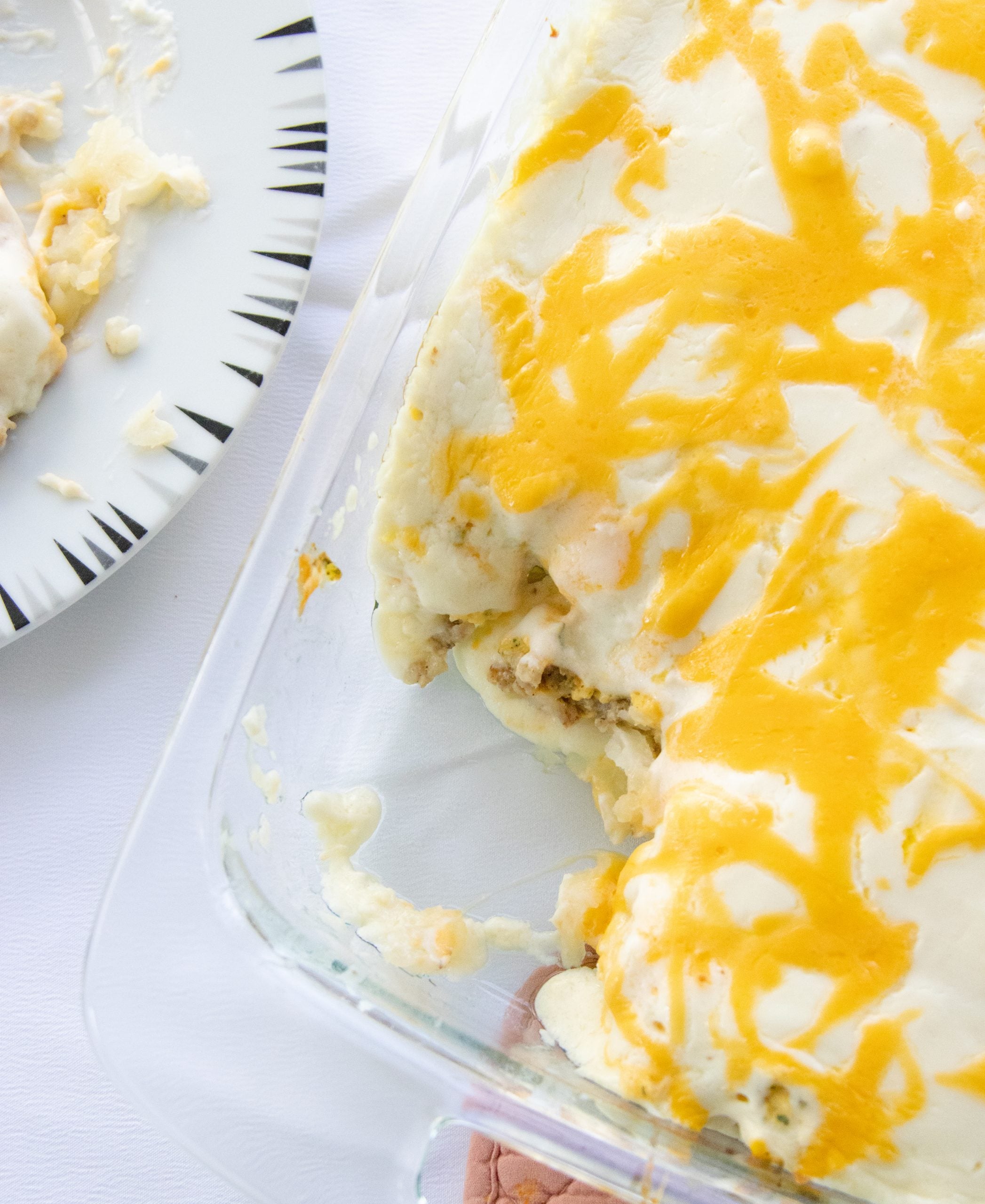 glass pan of finished gold rush breakfast casserole with a serving taken out of it