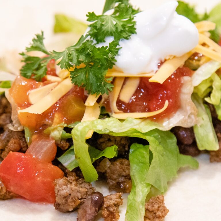 tortilla shell with taco meat and a bunch of toppings