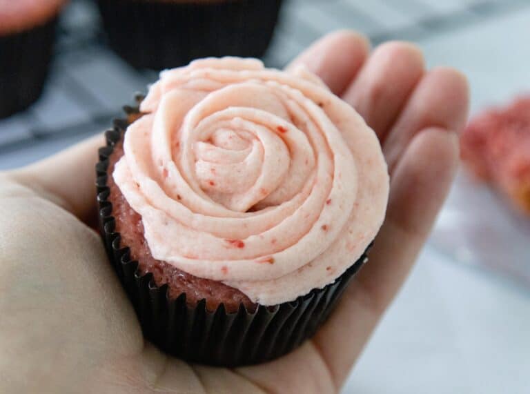hand holding a strawberry cupcake