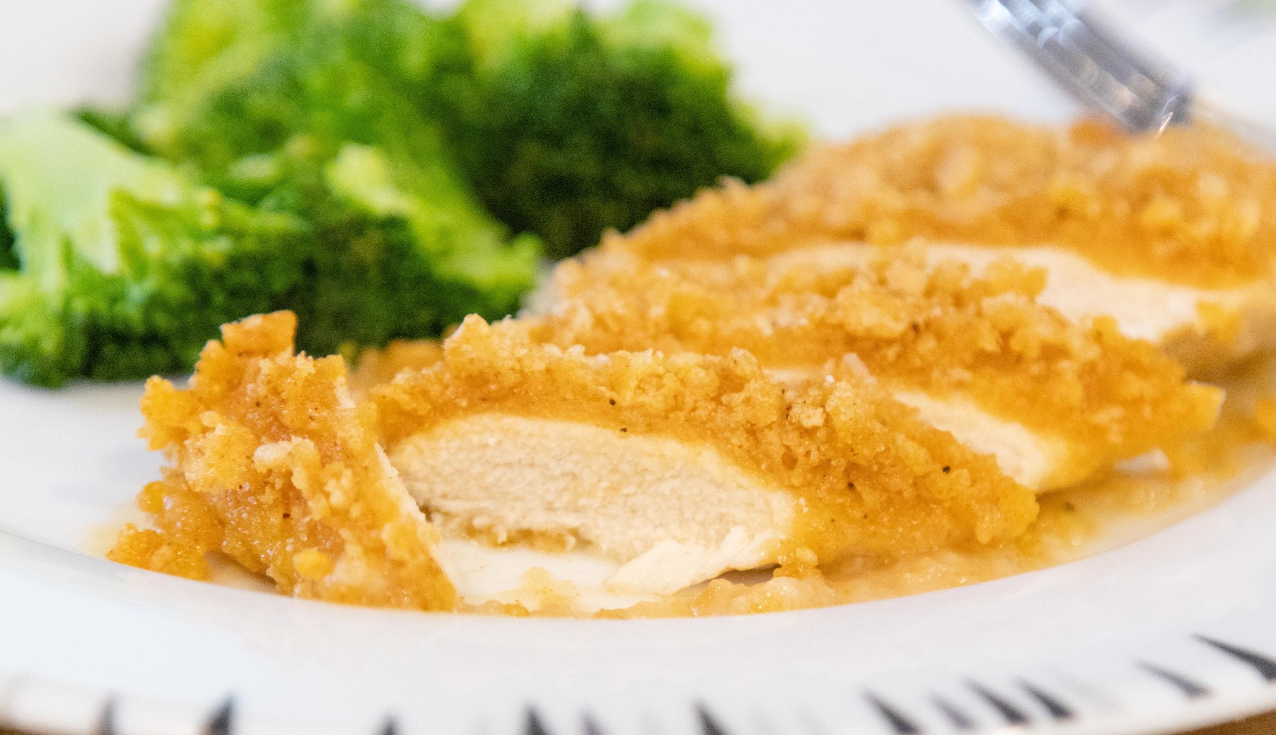 sliced crispy oven baked chicken breast on a plate