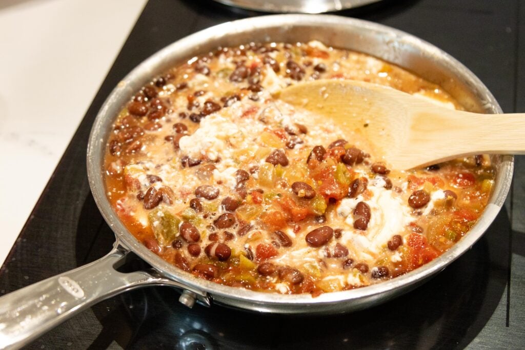 wooden spoon stirring the creamy salsa bean dip