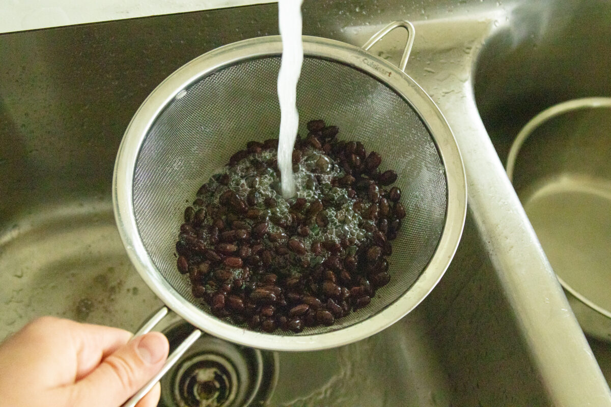 rinsing the beans in a strainer