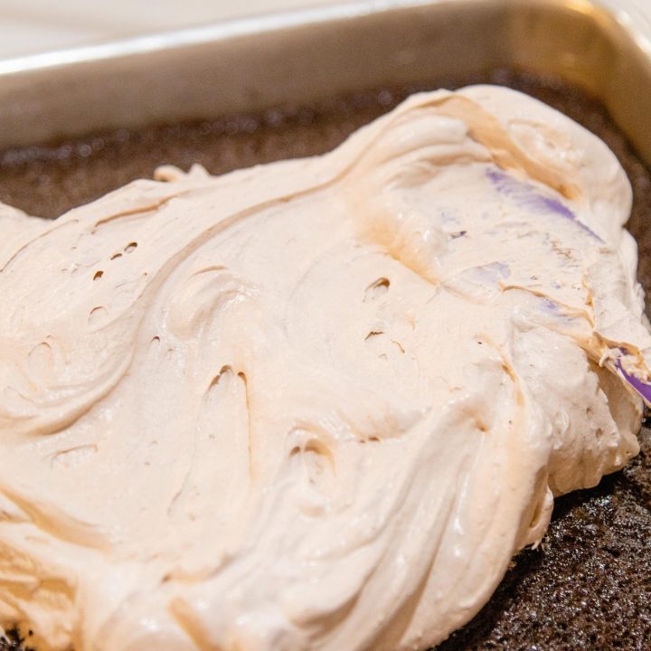 spreading the pudding frosting on a cake with a spatula