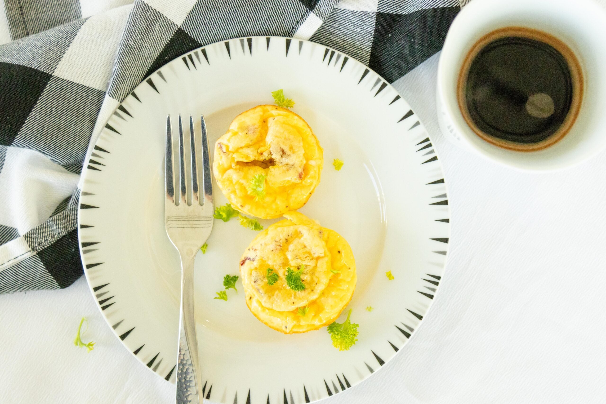 two egg bites on a white plate with a fork