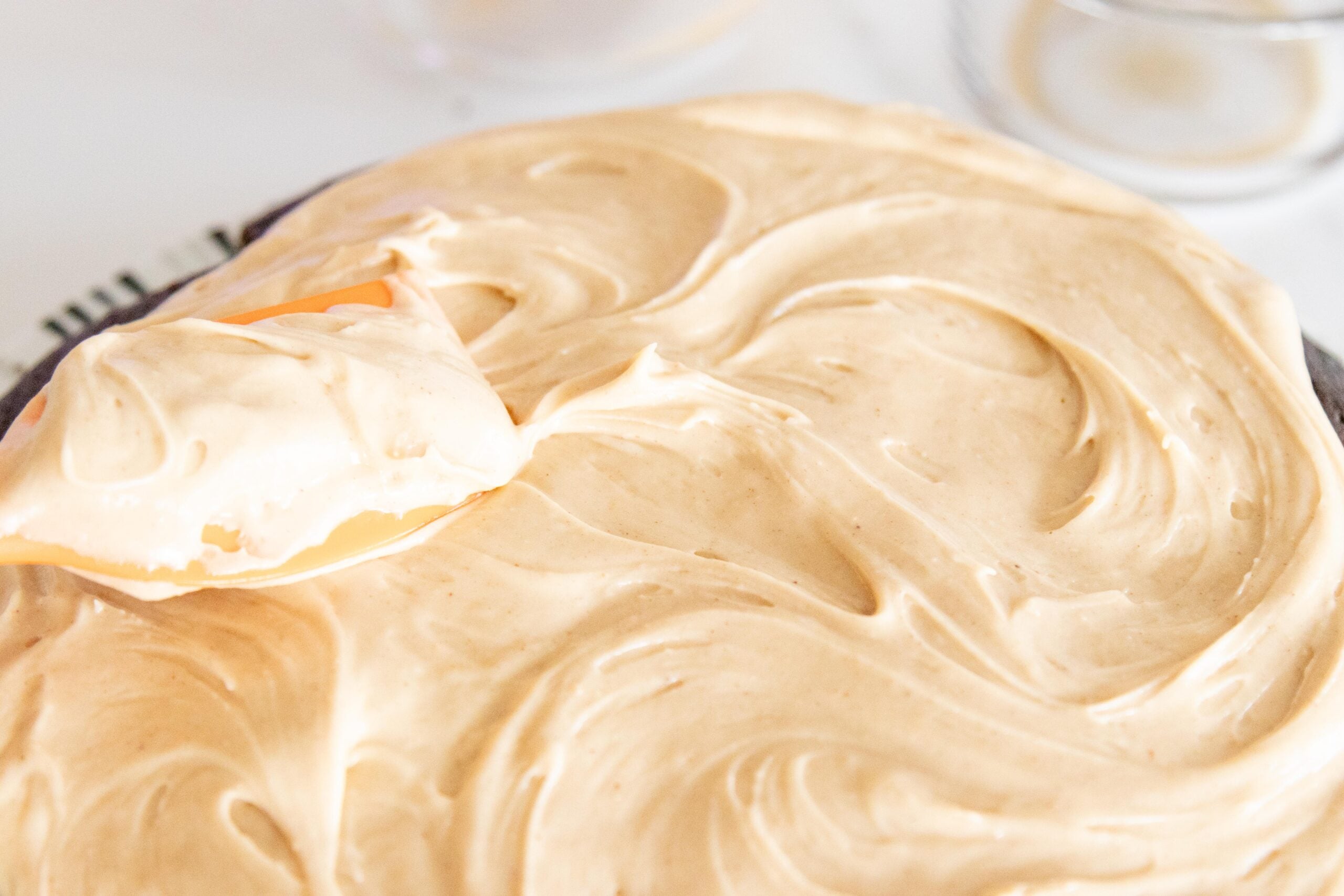 spreading the peanut butter frosting on a cake