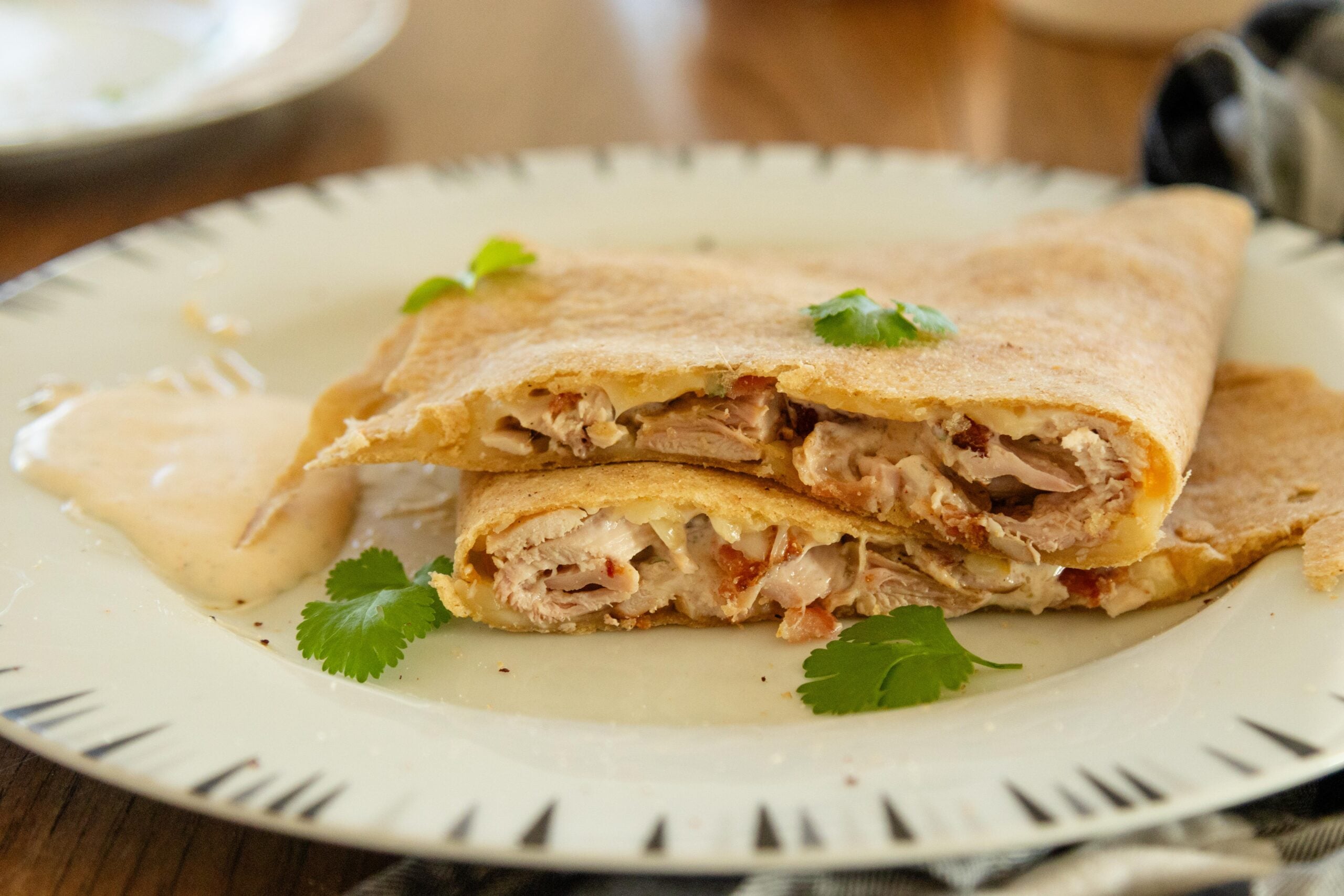 chicken bacon ranch quesadilla cut in half stacked on top of each other on a white plate