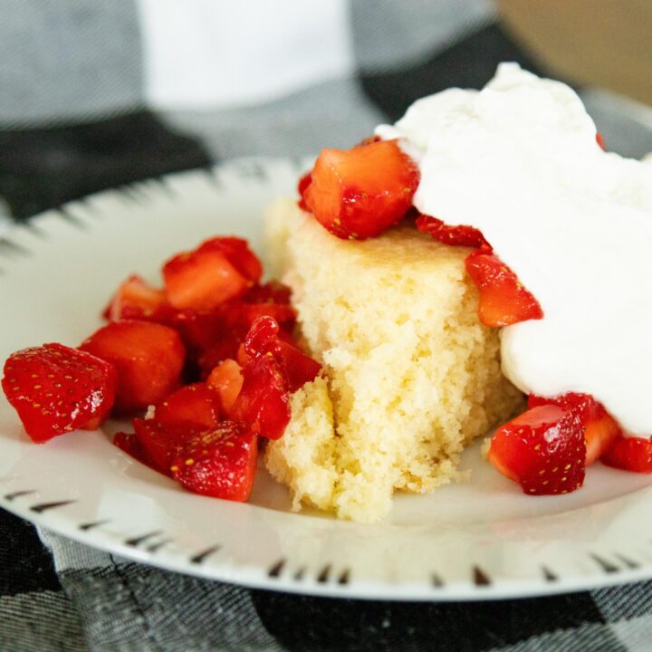shortcake, strawberries and whipped cream on a white plate