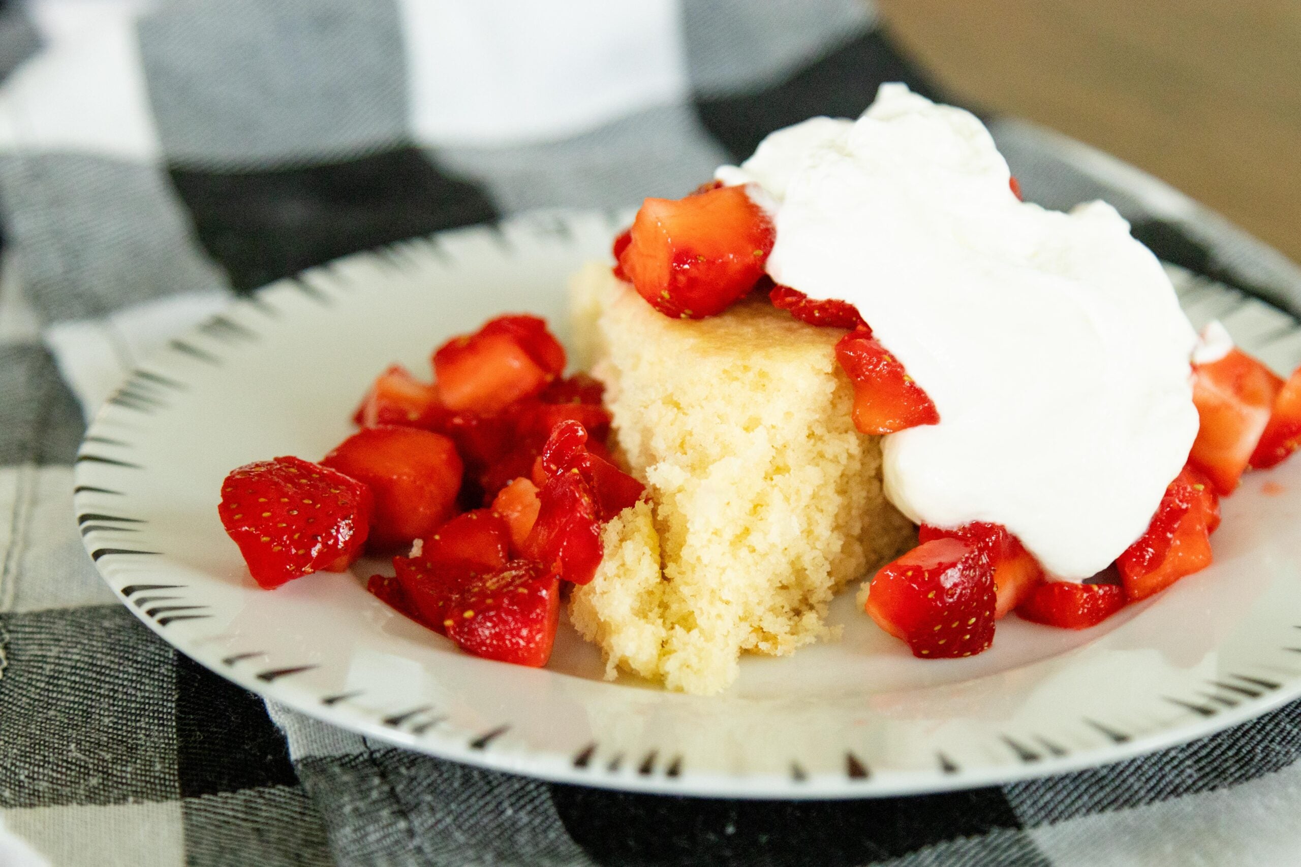 shortcake, strawberries and whipped cream on a white plate