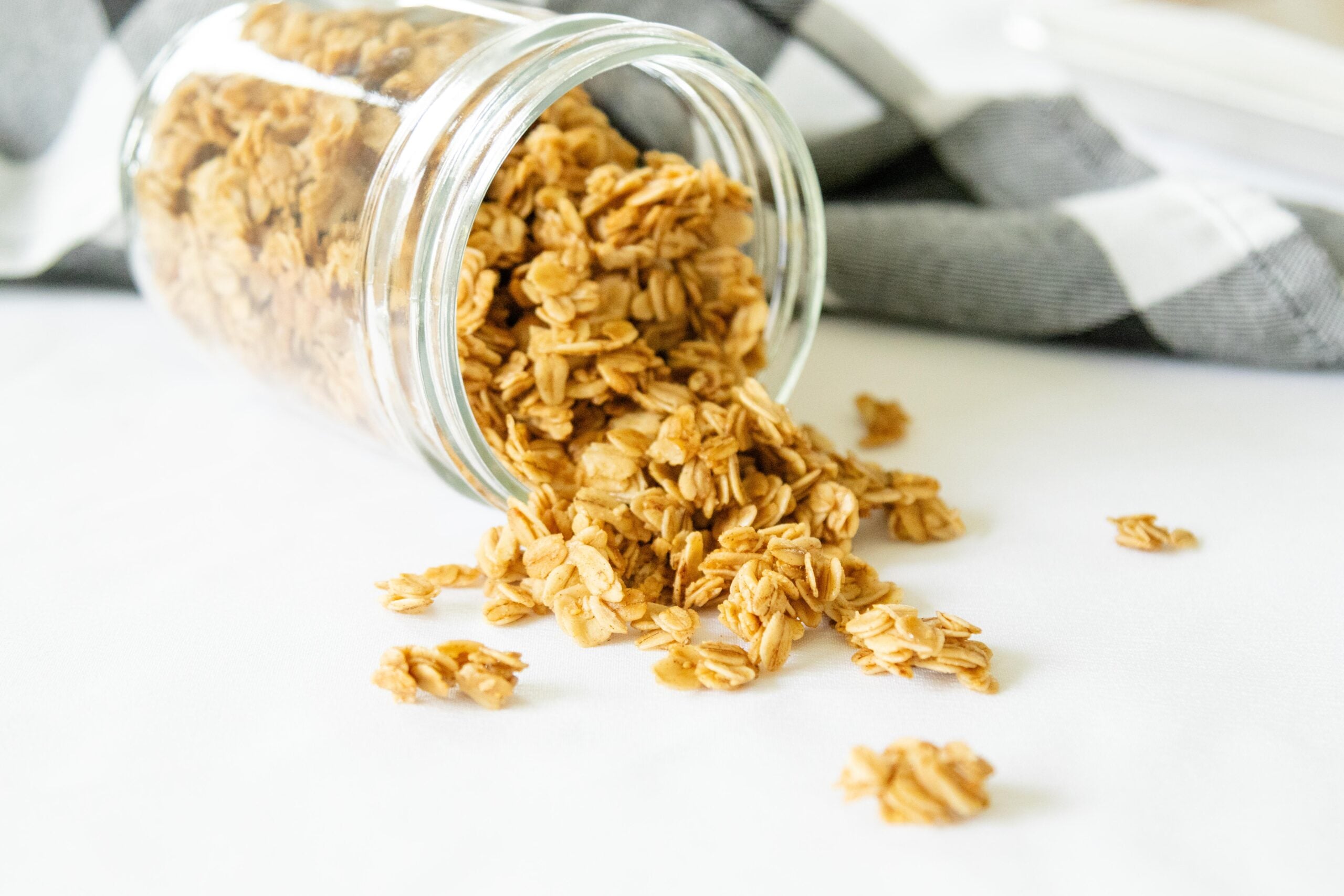 fresh maple cinnamon granola in a jar tipped on its side