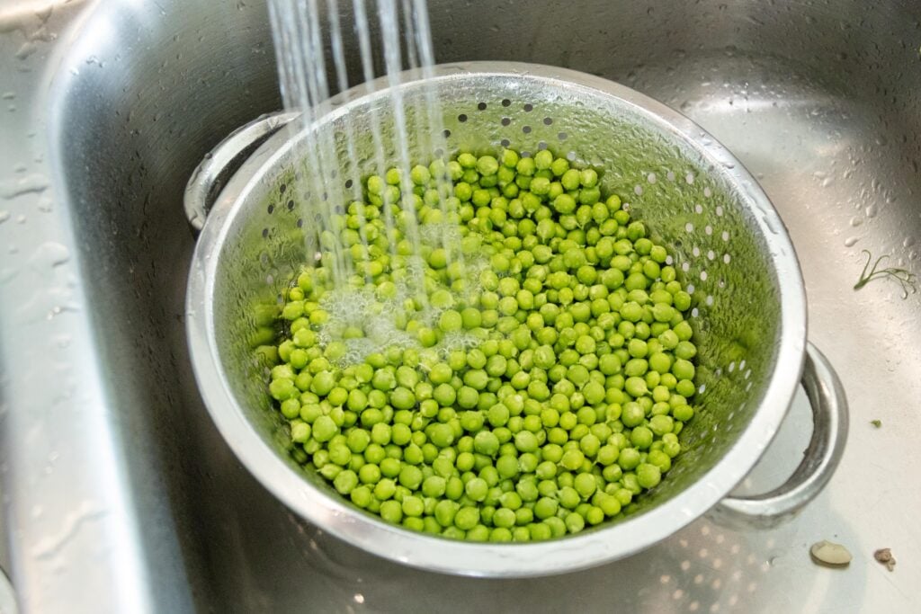 rinsing the peas in the sink