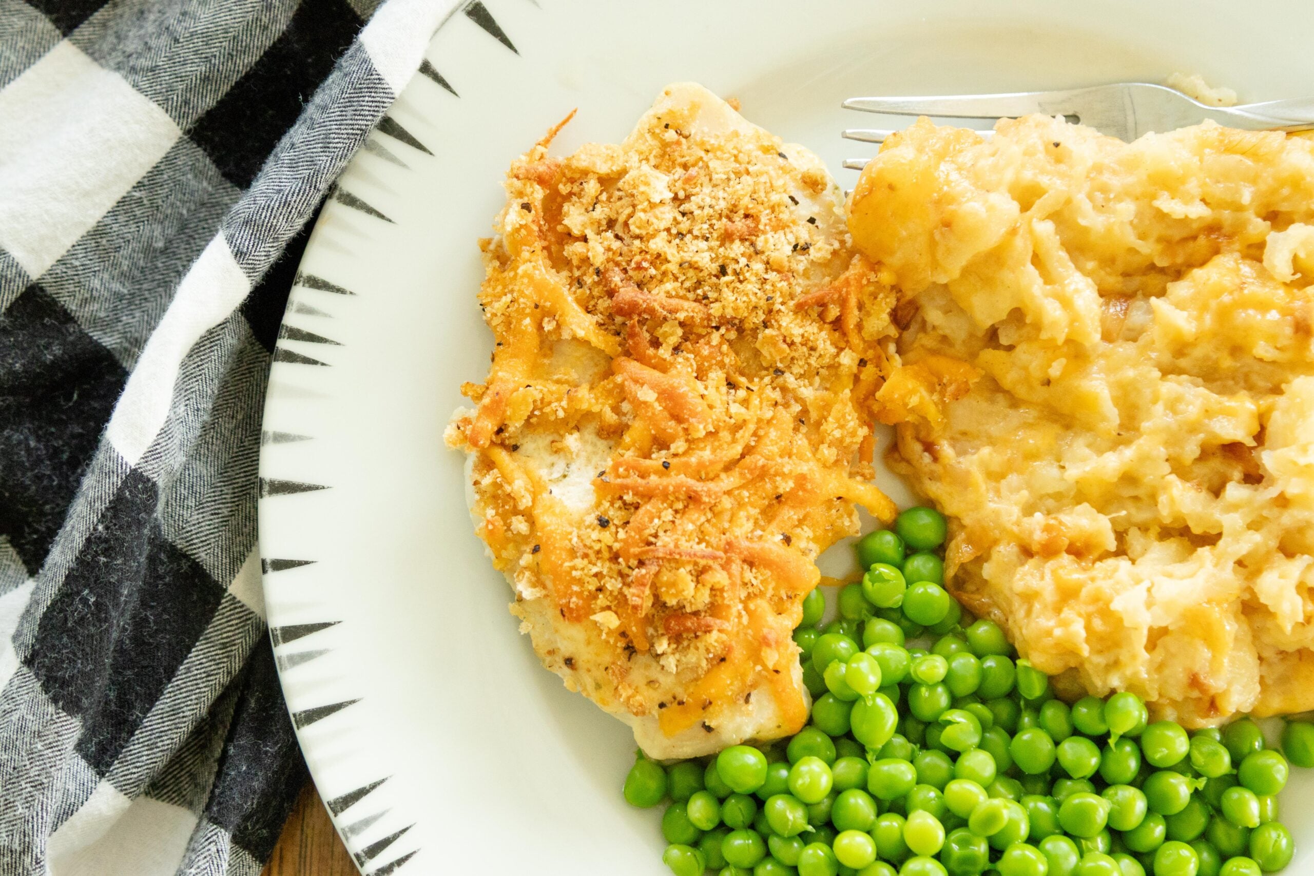 one cheddar ranch chicken breast on a plate with peas and potatoes