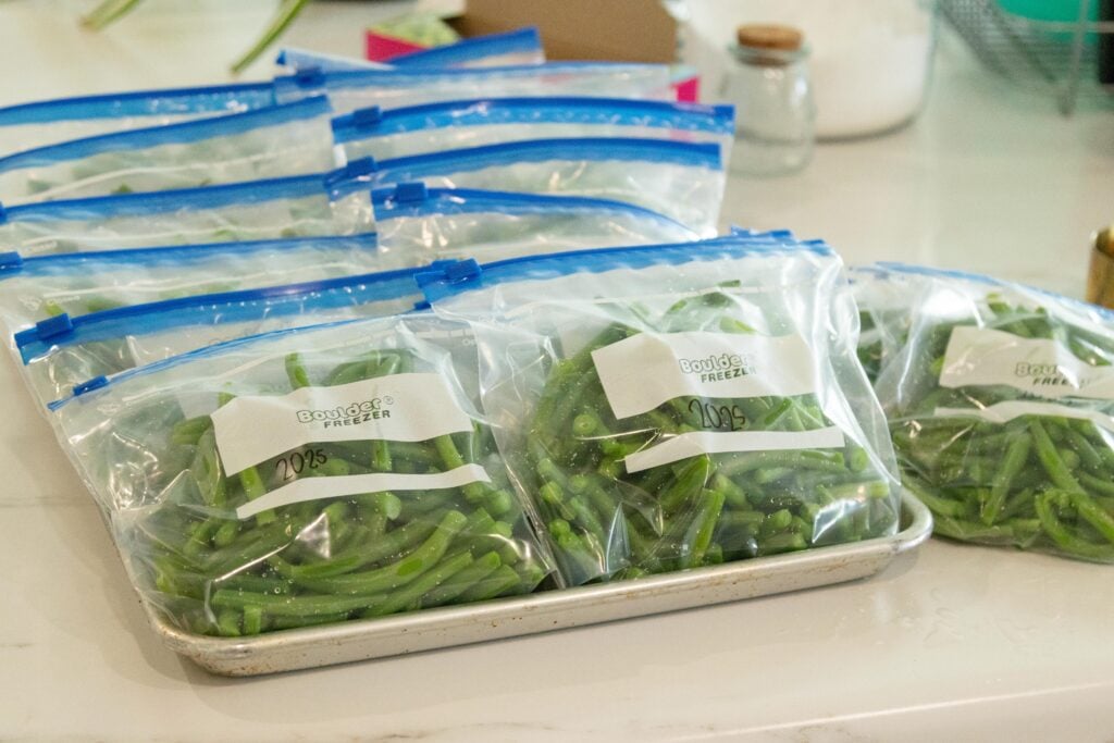a tray of bagged green beans ready for the freezer
