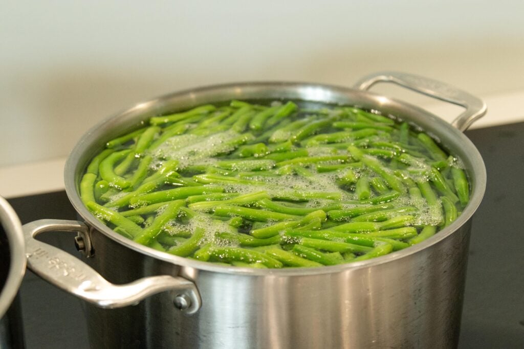 green beans in boiling water on the stovetop