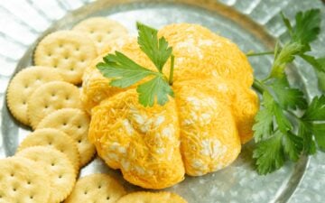 cheeseball pumpkin and crackers on a platter