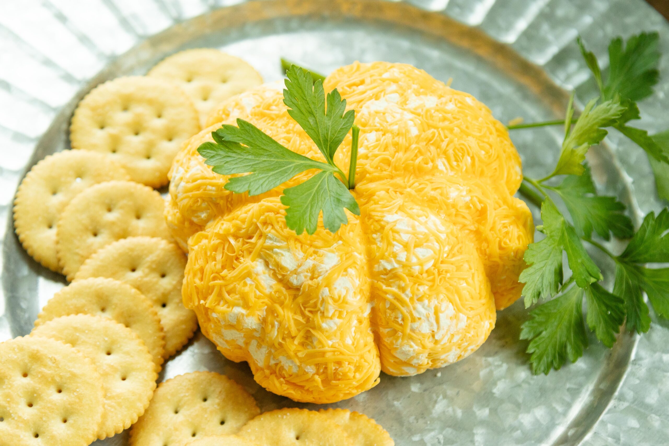 cheeseball pumpkin and crackers on a platter