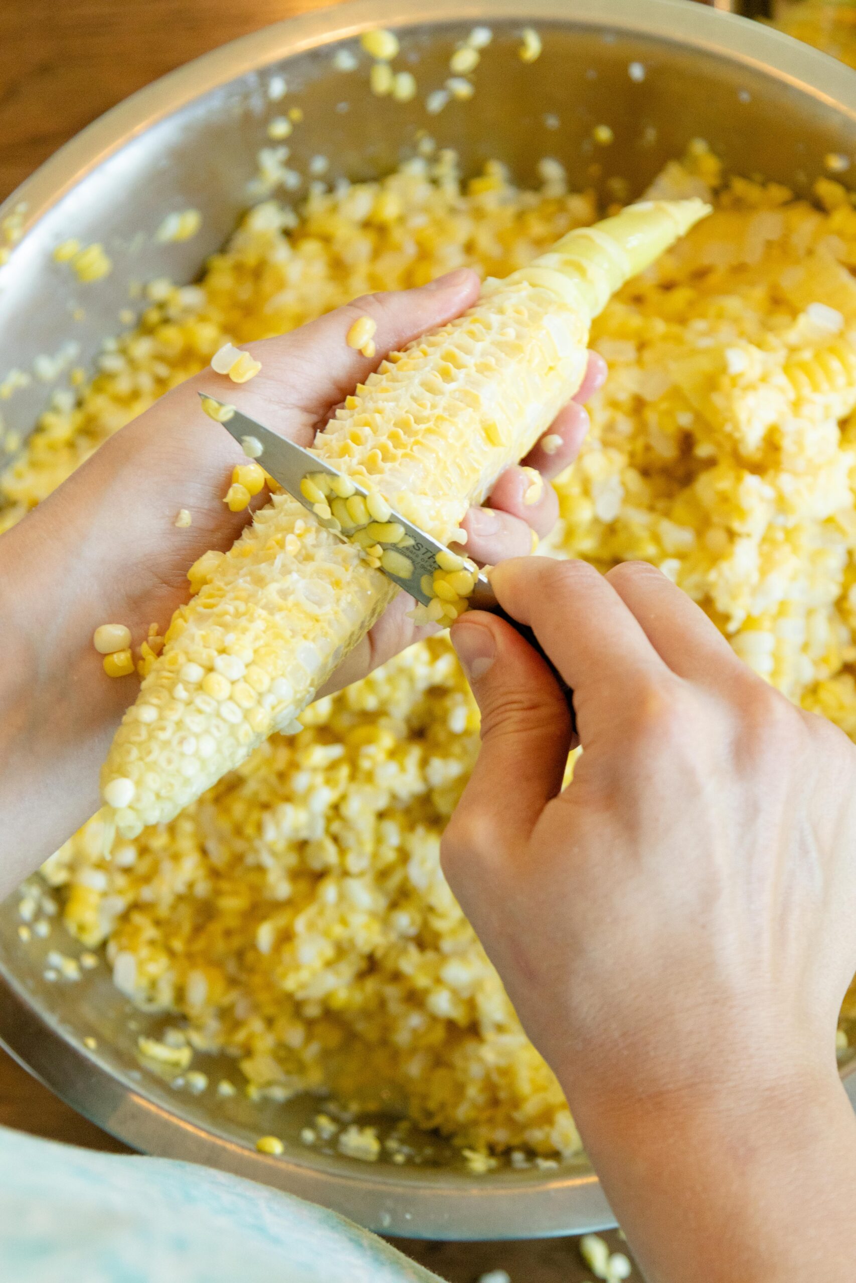 cutting the corn from the cob into a dish