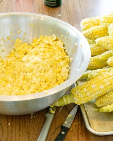 corn cons stacked on a tray with a dish of cut corn sitting beside