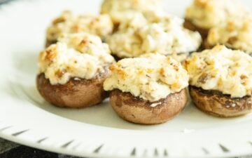 stuffed mushrooms setting on a white plate