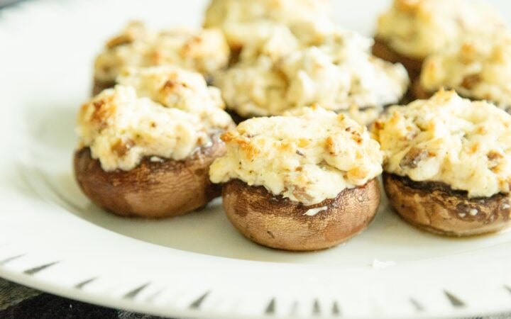 stuffed mushrooms setting on a white plate