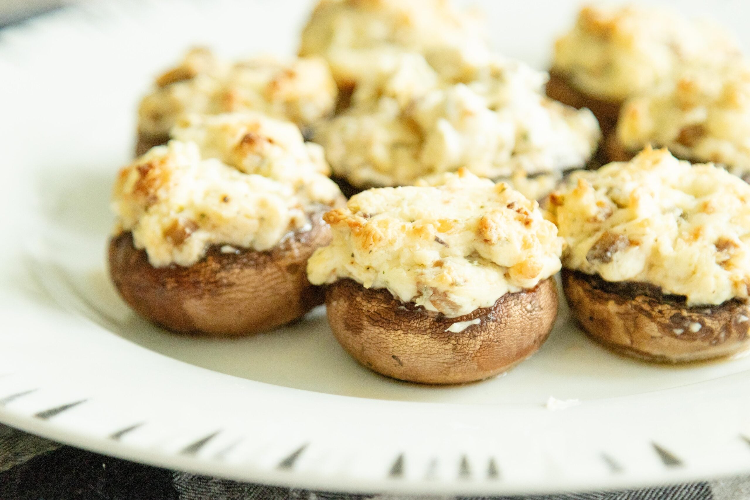 stuffed mushrooms setting on a white plate