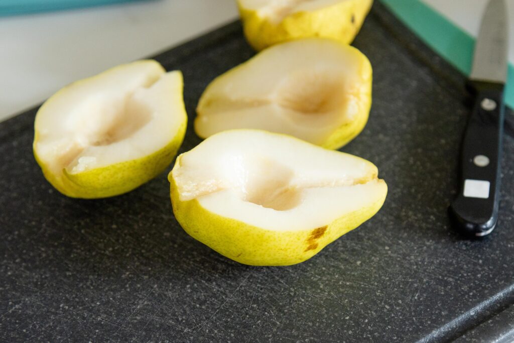 cored pear halves laying on a cutting board