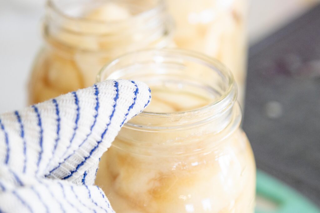 wiping the jar rims with a clean damp cloth