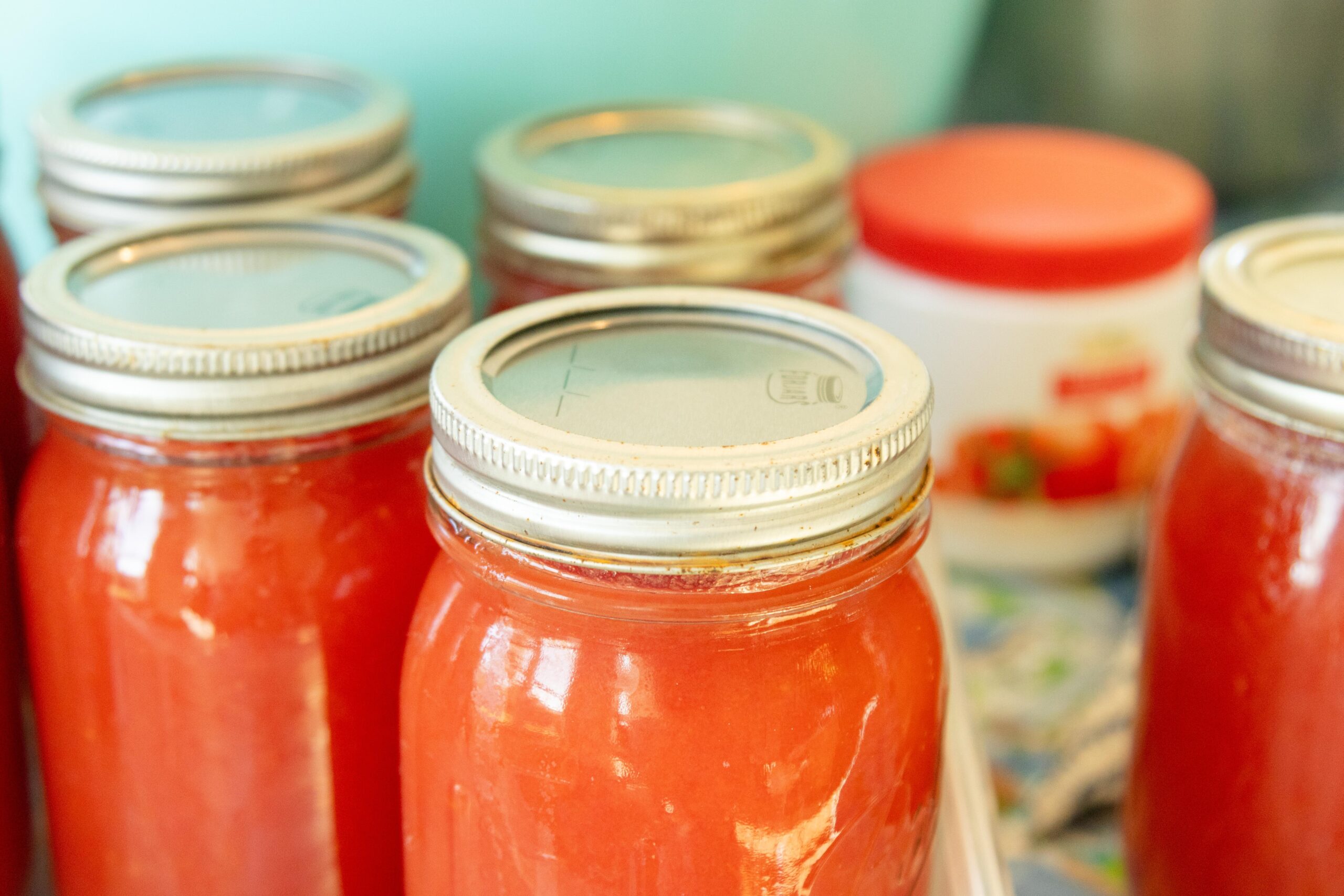 filled jars of tomato juice setting on the table