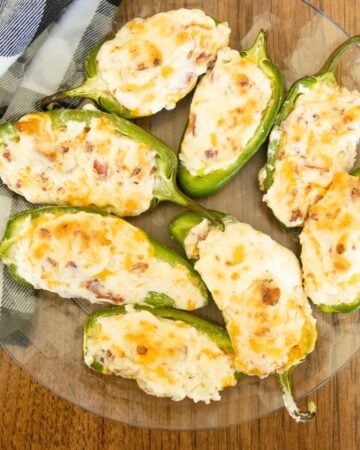 a plate full of jalapeno poppers on the table beside a checkered napkin