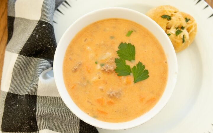 a bowl full of hearty hamburger soup on a white plate