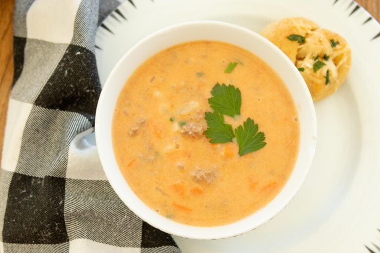a bowl full of hearty hamburger soup on a white plate