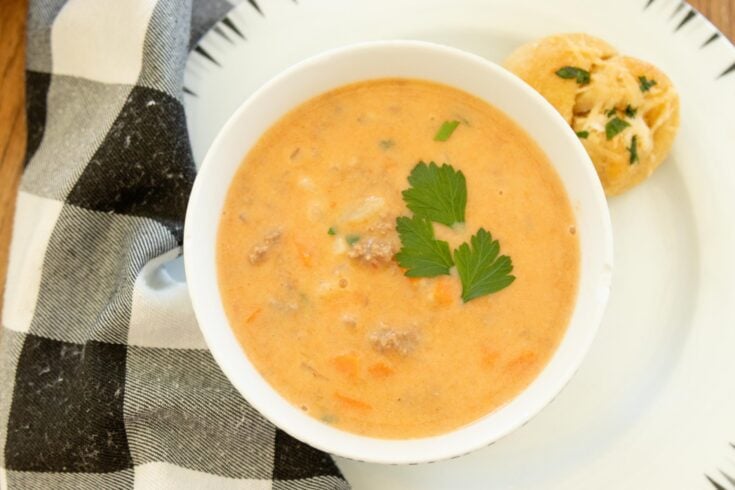 a bowl full of hearty hamburger soup on a white plate