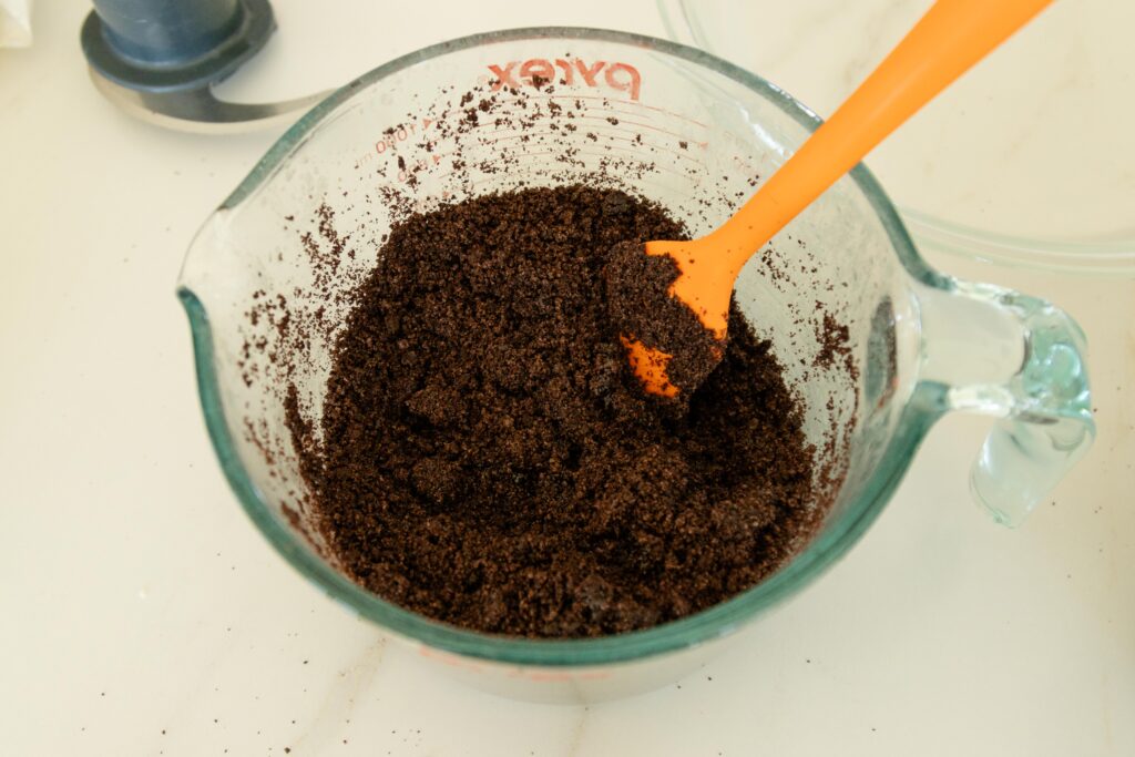 mixing the butter and oreo crumbs in a bowl