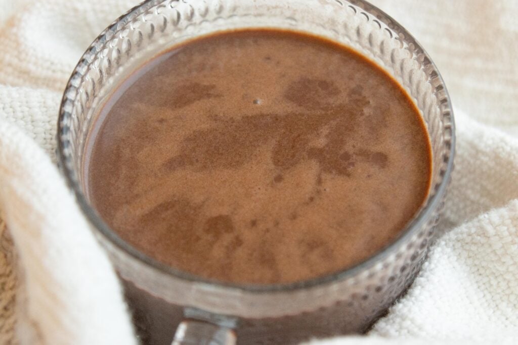 a clear glass mug of hot chocolate