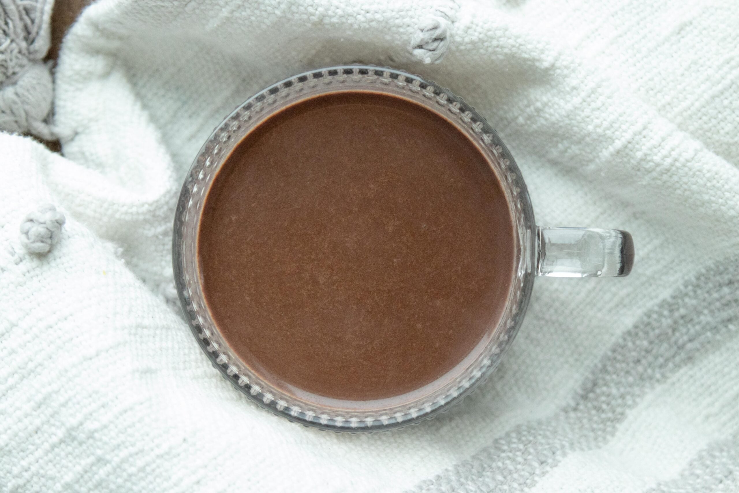 a clear glass mug of hot chocolate