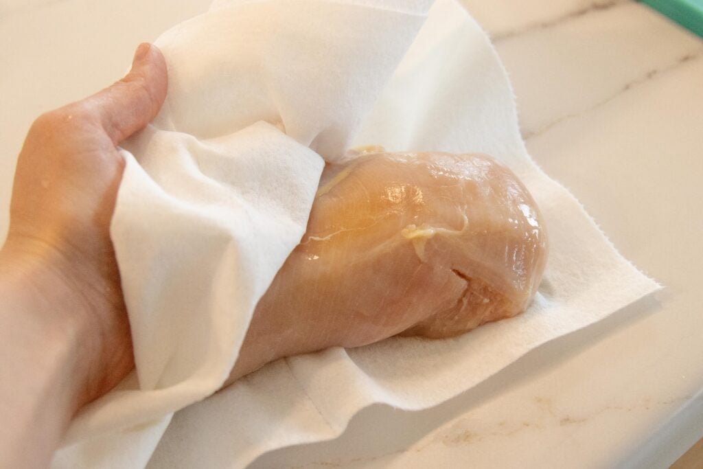 patting the chicken dry with a paper towel
