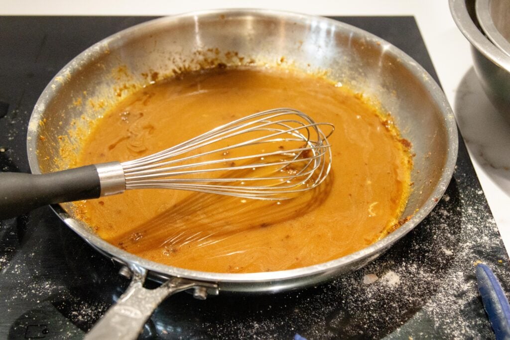 whisking the sweet and sour sauce in the pan
