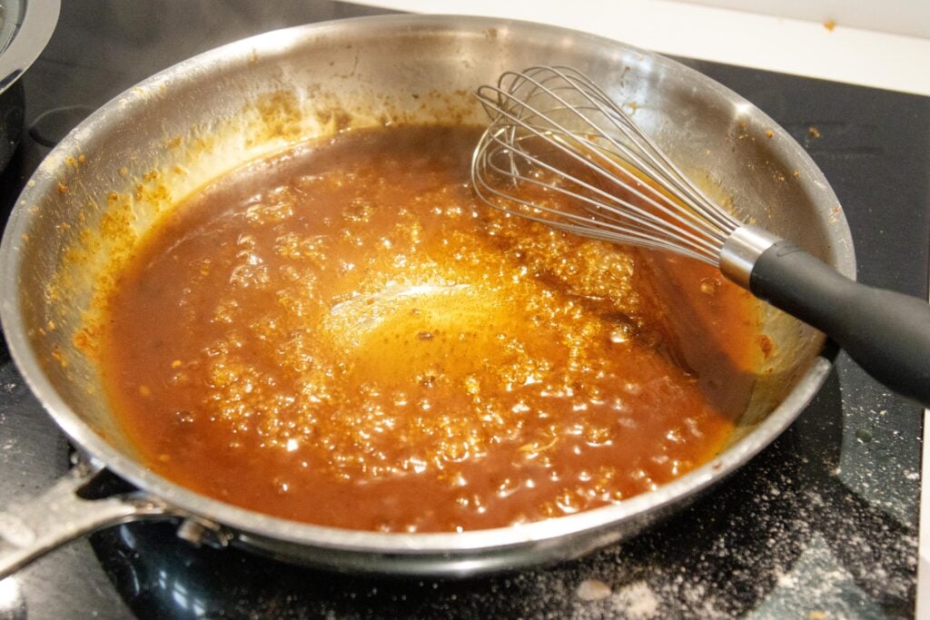 whisking the sweet and sour sauce in a pan