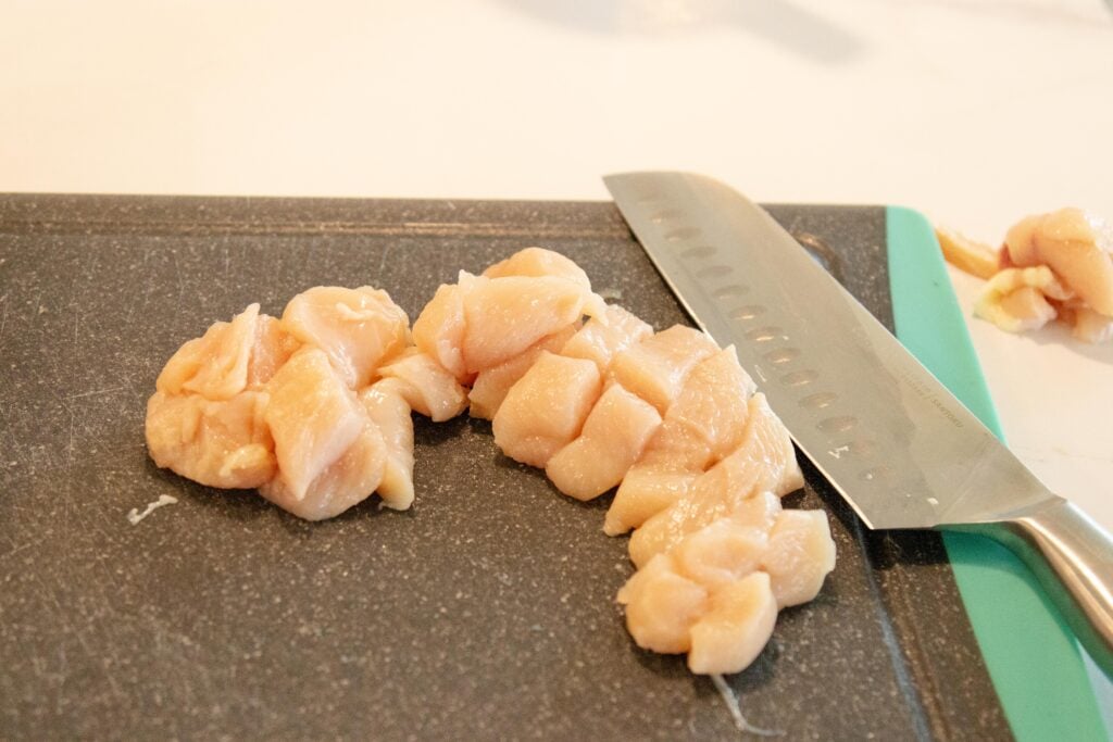 chopping the chicken on a cutting board