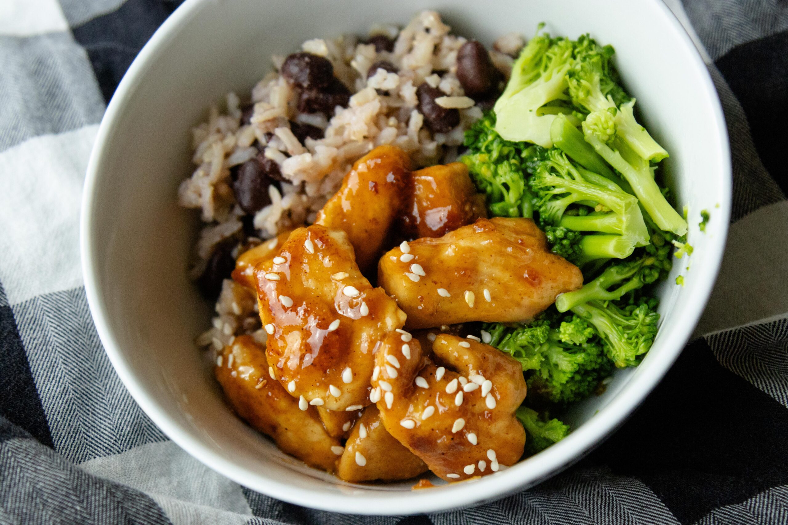 a bowl of rice, broccoli and sweet and sour chicken
