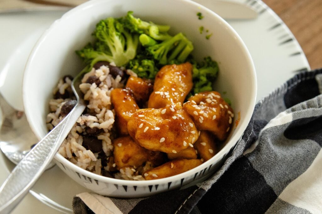 a bowl of rice, broccoli and sweet and sour chicken