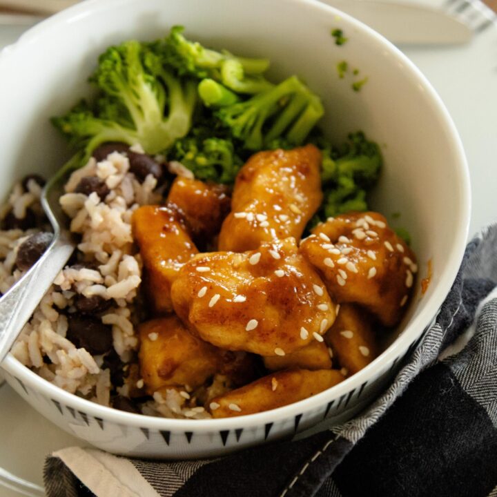a bowl of rice, broccoli and sweet and sour chicken