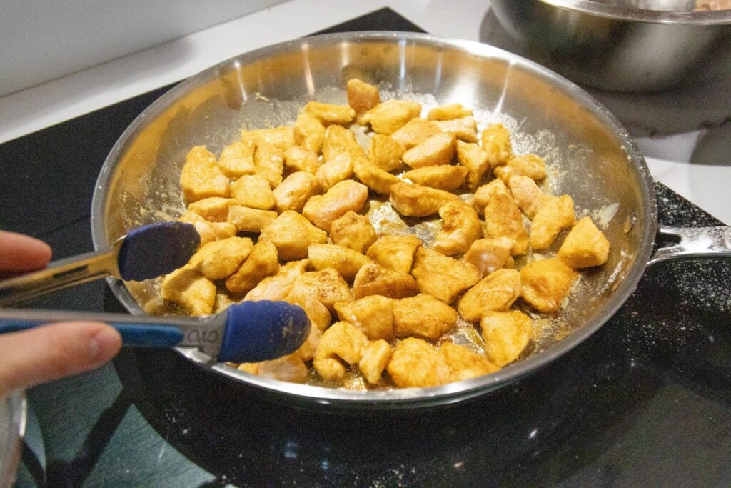 the chicken frying in a pan