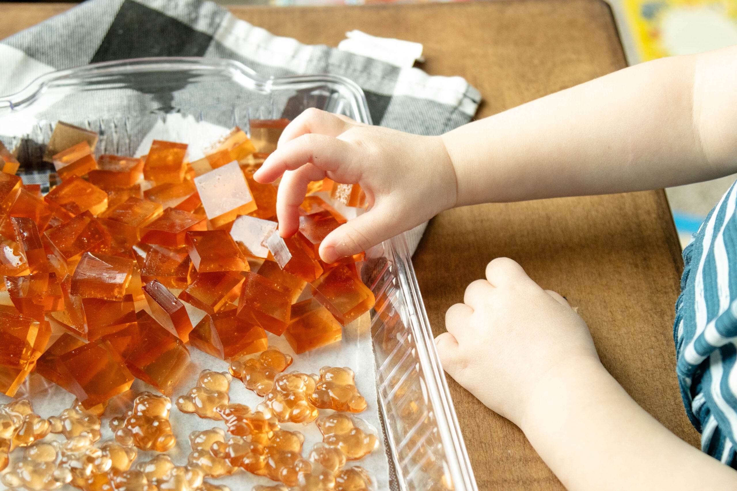 little hand grabbing a gummy off the tray