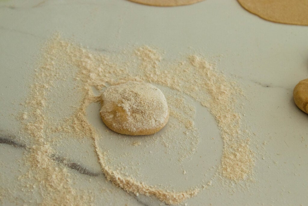 a ball of dough in the flour on the counter
