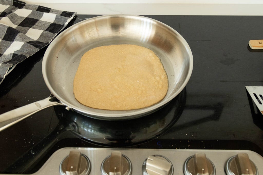 a tortilla frying on the stovetop