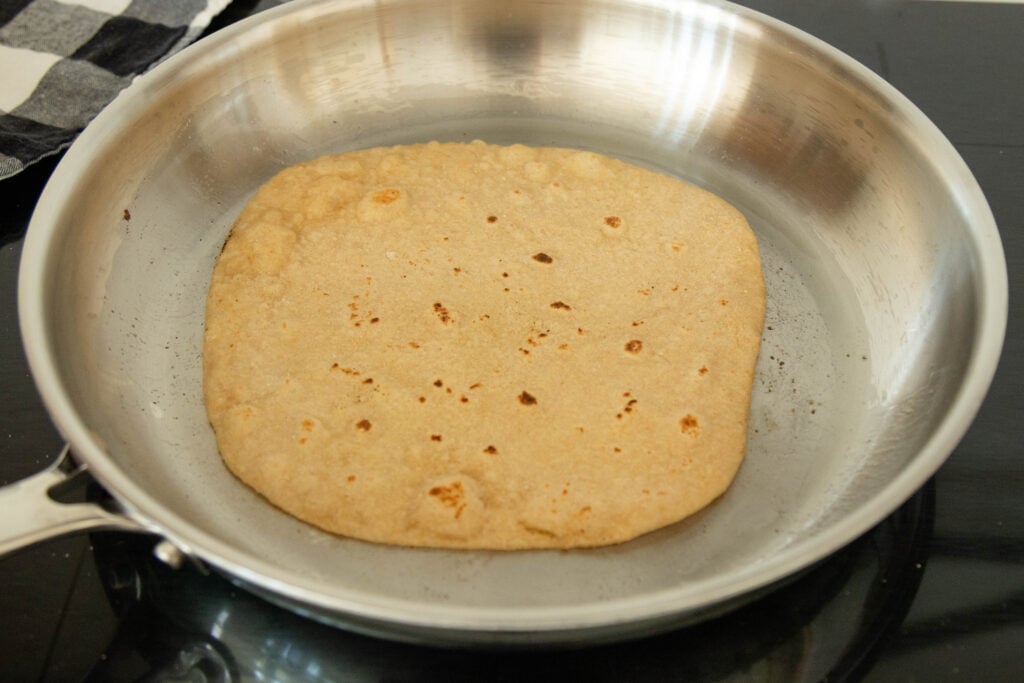 a fresh tortilla in the frying pan