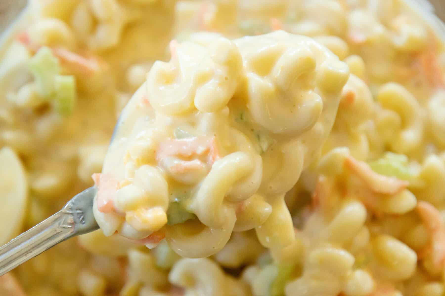 close up shot of a spoon full of macaroni salad