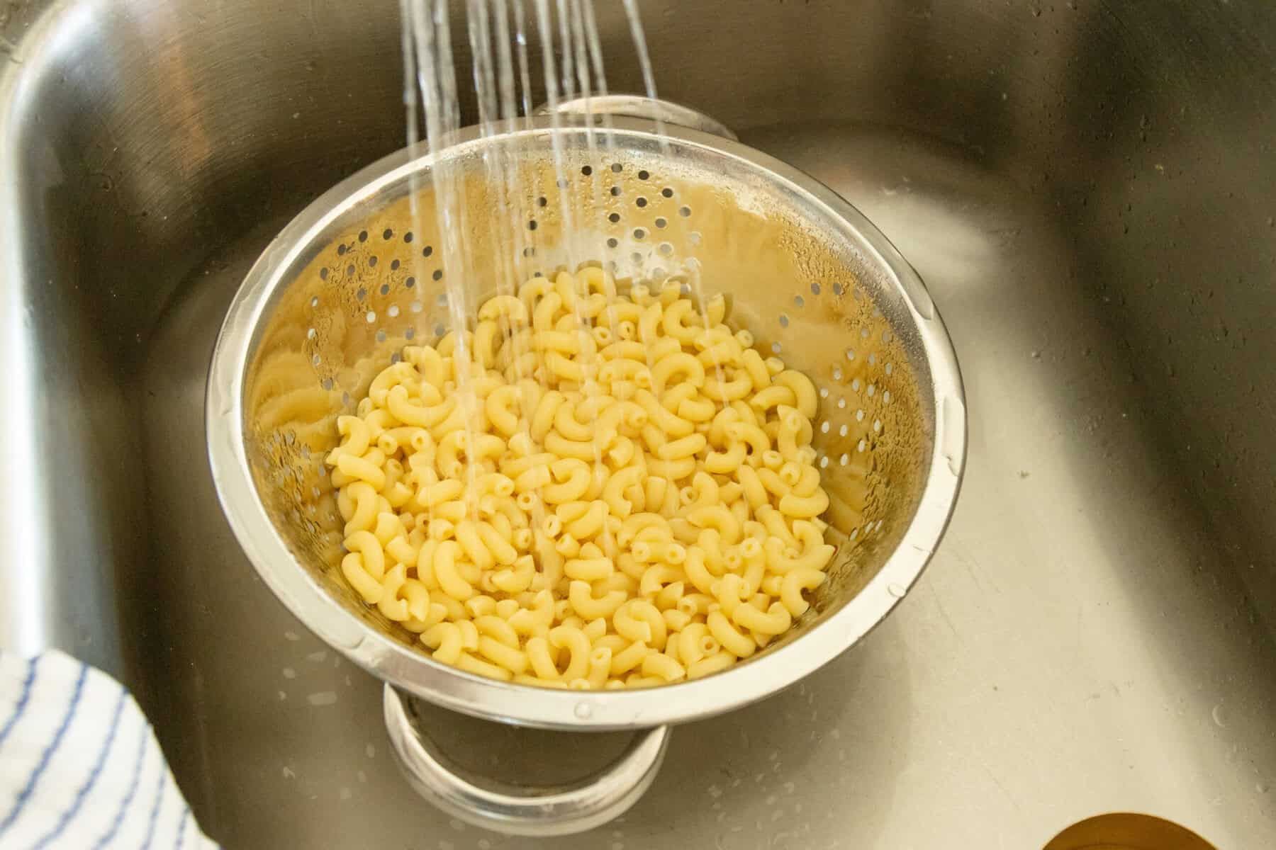 rinsing the macaroni under running water